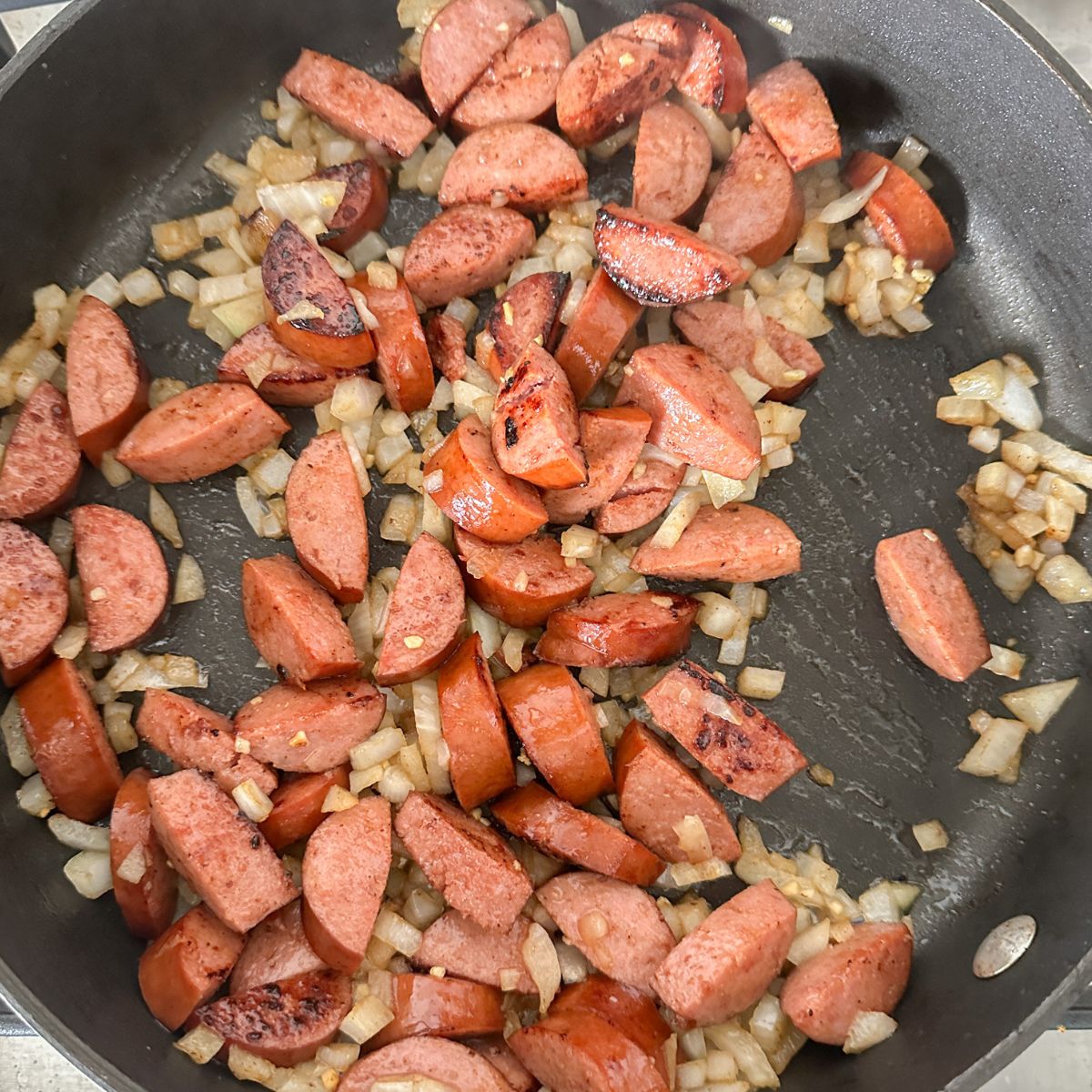 Skillet with kielbasa and onion.