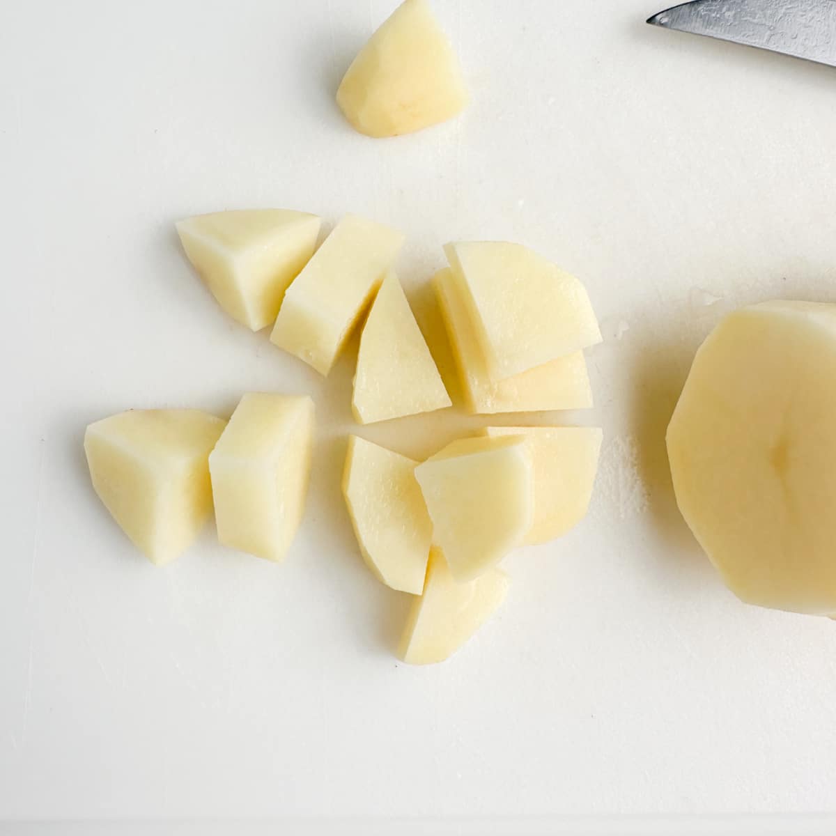 Cutting board with cut potatoes.