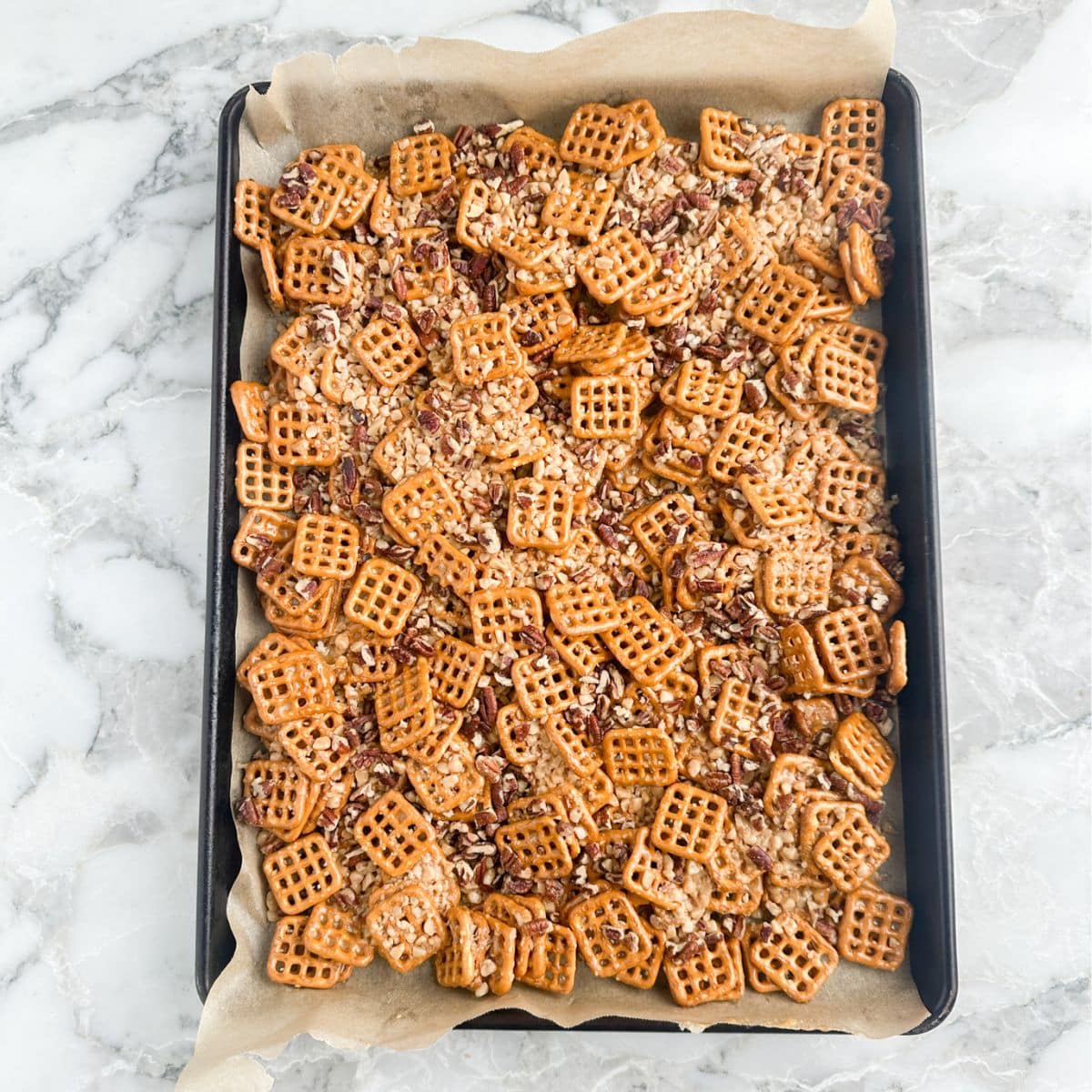 Baking pan with pretzels covered in toffee bits. 