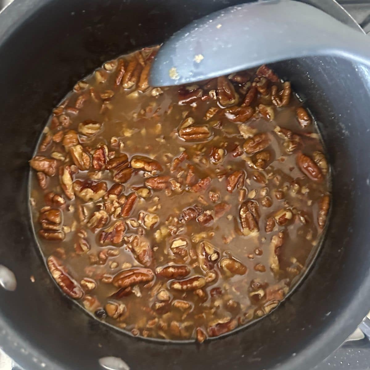 Saucepan with pecan pie mixture.