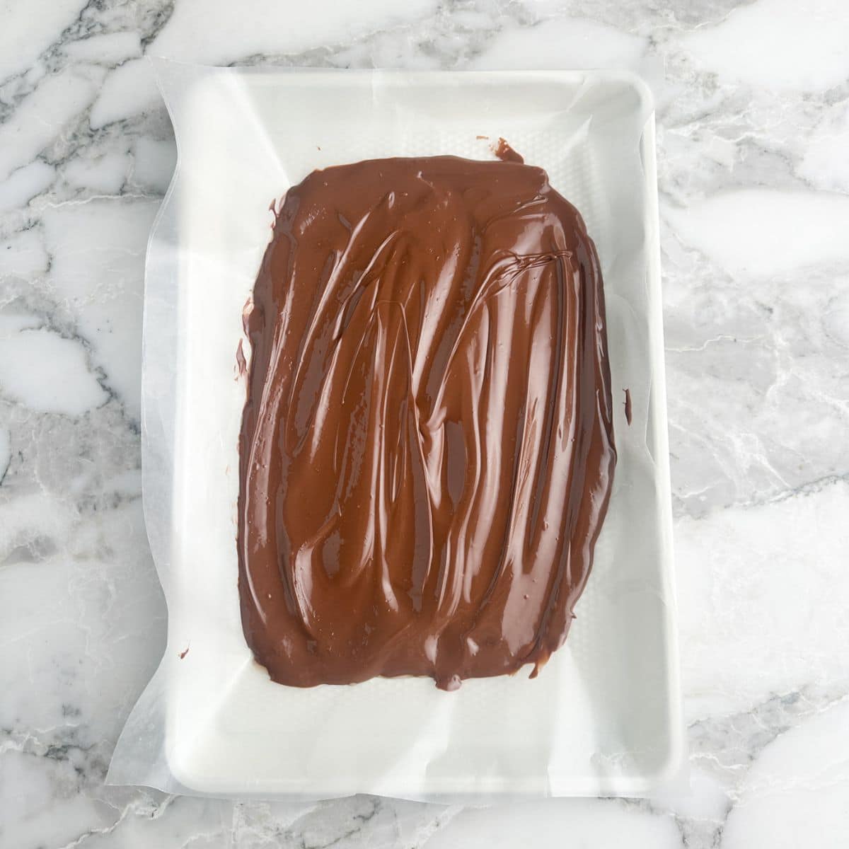 Wax paper with melted chocolate spread on it. 