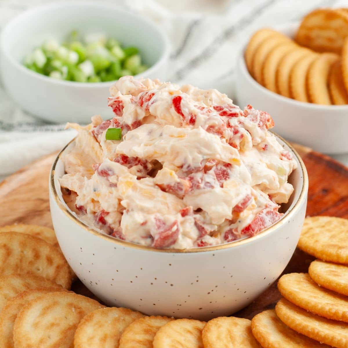 Bowl of creamy roasted red pepper dip with crackers. 