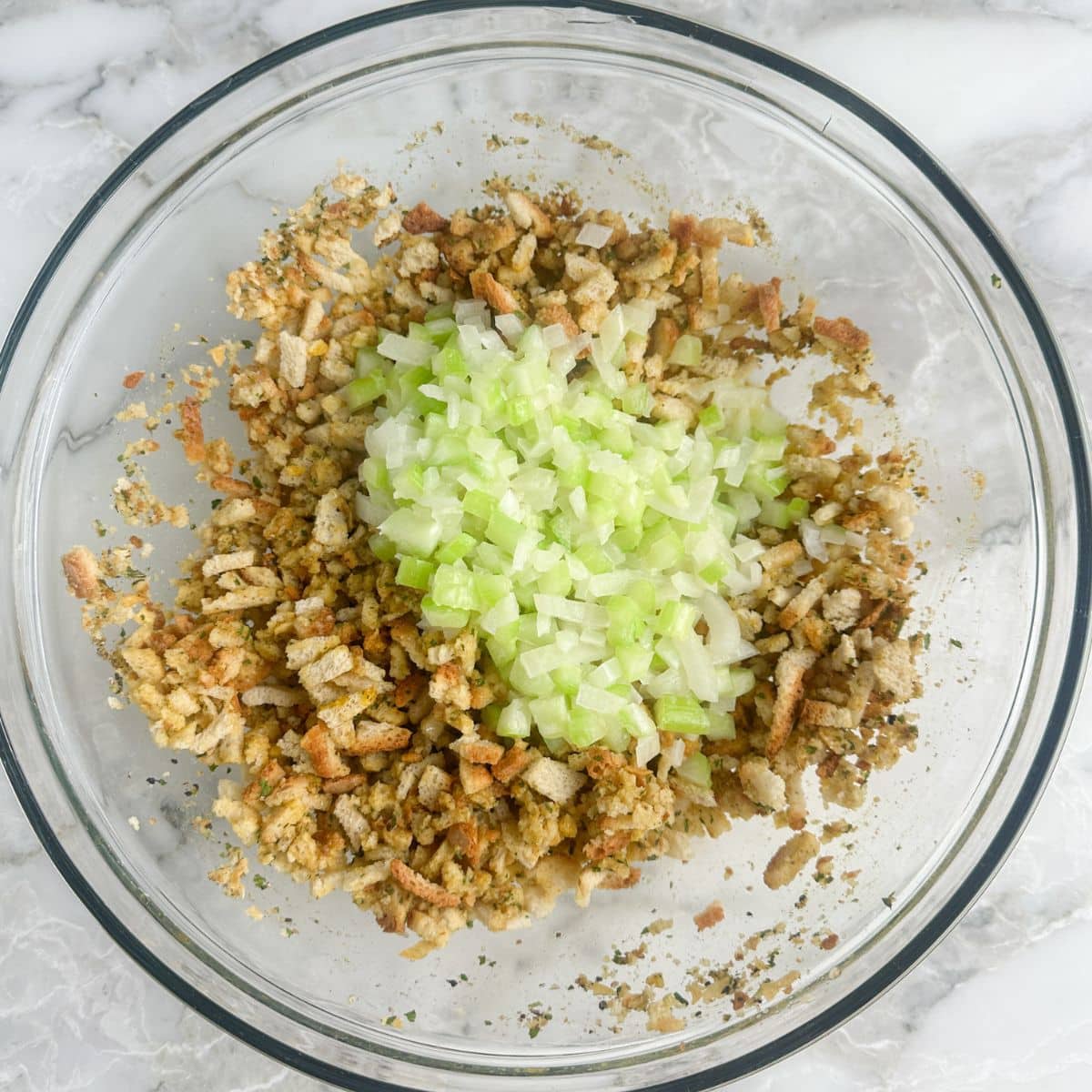 Bowl with stuffing mix, celery, onion, and melted butter. 