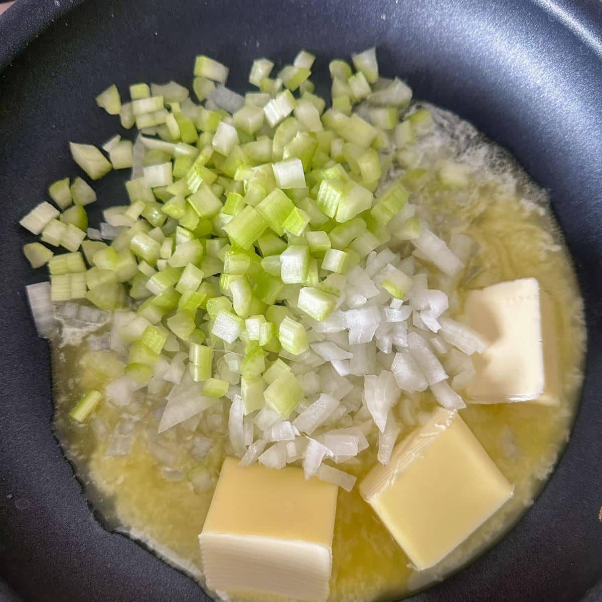 Skillet with butter, diced celery and onion. 