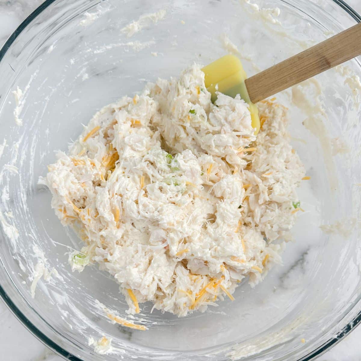 Bowl of cold crab dip with a spatula.