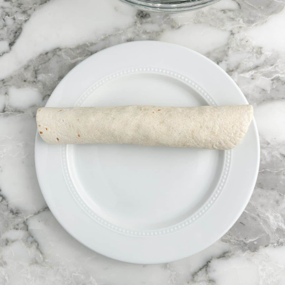 Rolled up tortilla on a plate. 