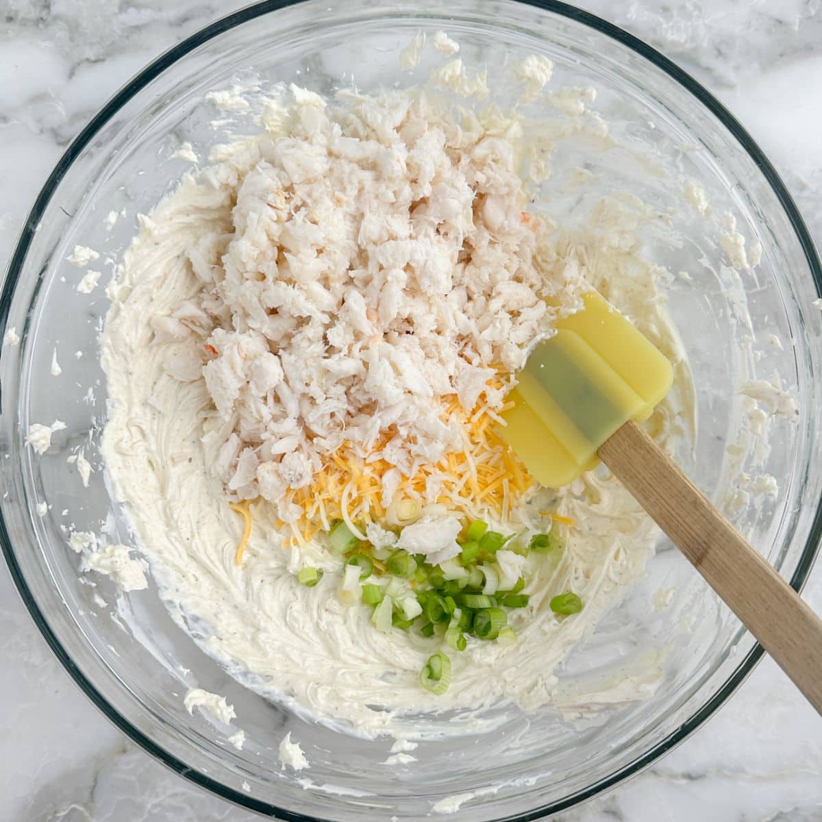 Bowl with crab meat, cheese, green onion, and whipped cream cheese. 