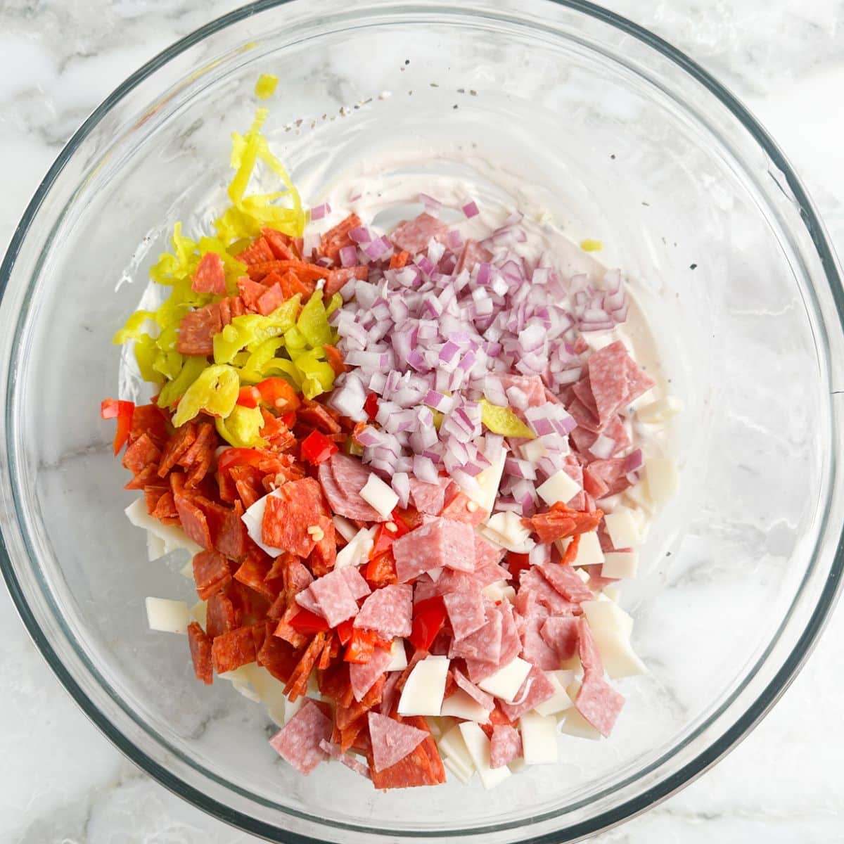 Bowl of chopped salami, pepperoni, diced onion. 