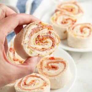 Hand holding an Italian pinwheel appetizer.