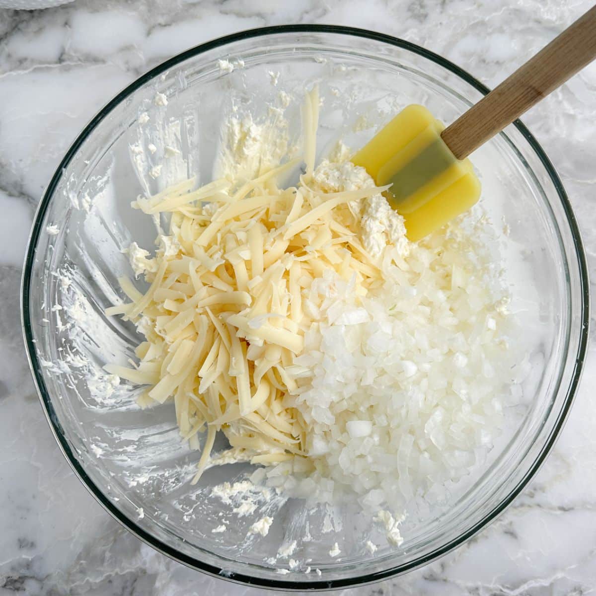 Bowl with cream cheese and shredded cheese. 