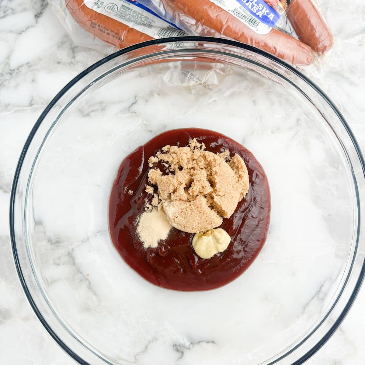 Bowl with BBQ sauce, brown sugar, and mustard. 