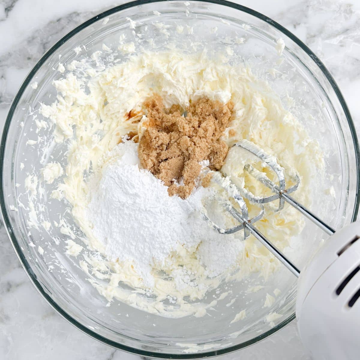 Bowl with cream cheese, powdered sugar, and brown sugar. 