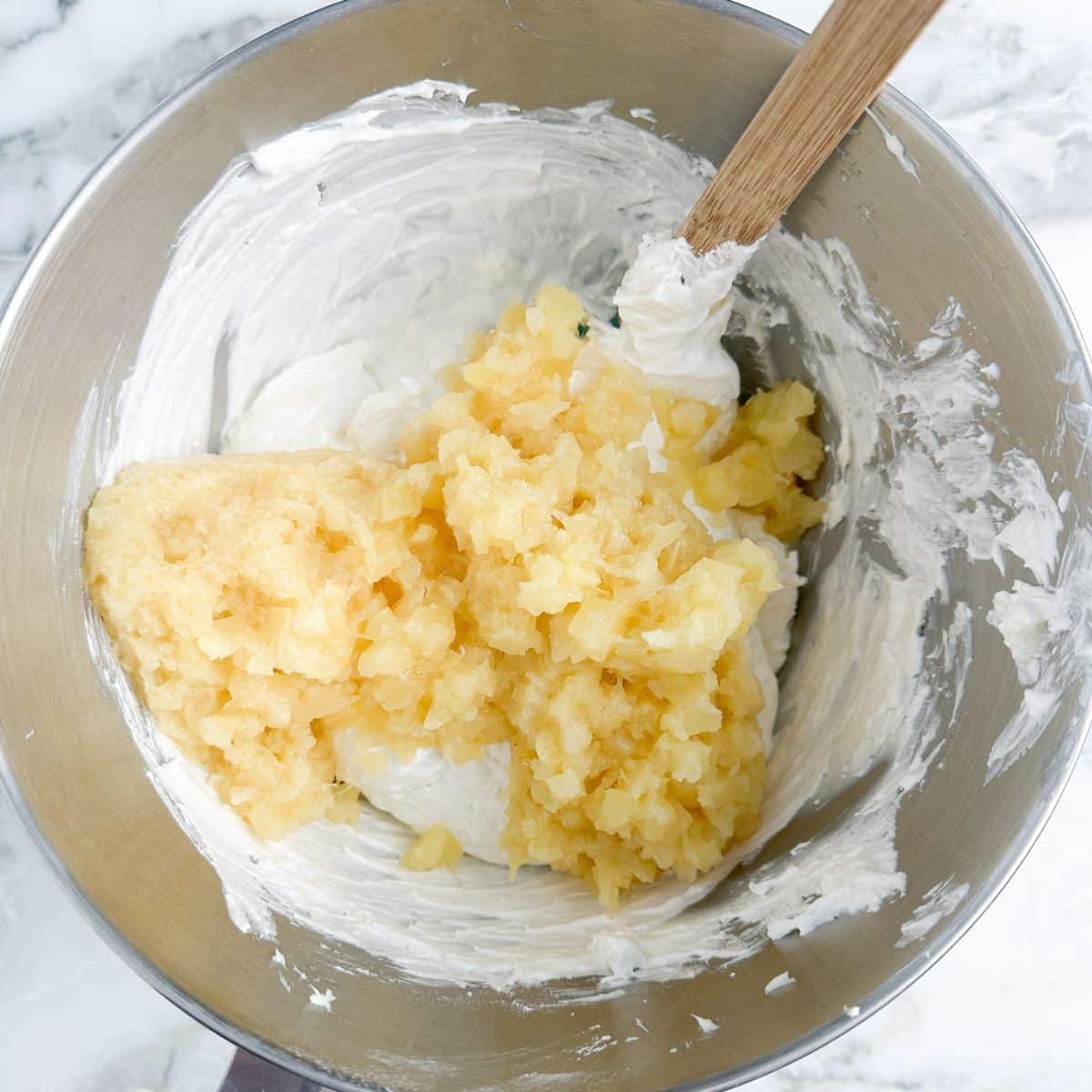 Bowl with cream cheese and crushed pineapple. 