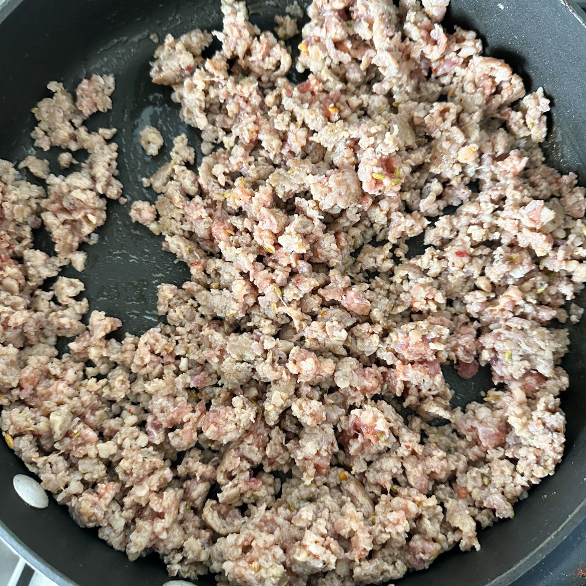 Skillet with ground Italian sausage.