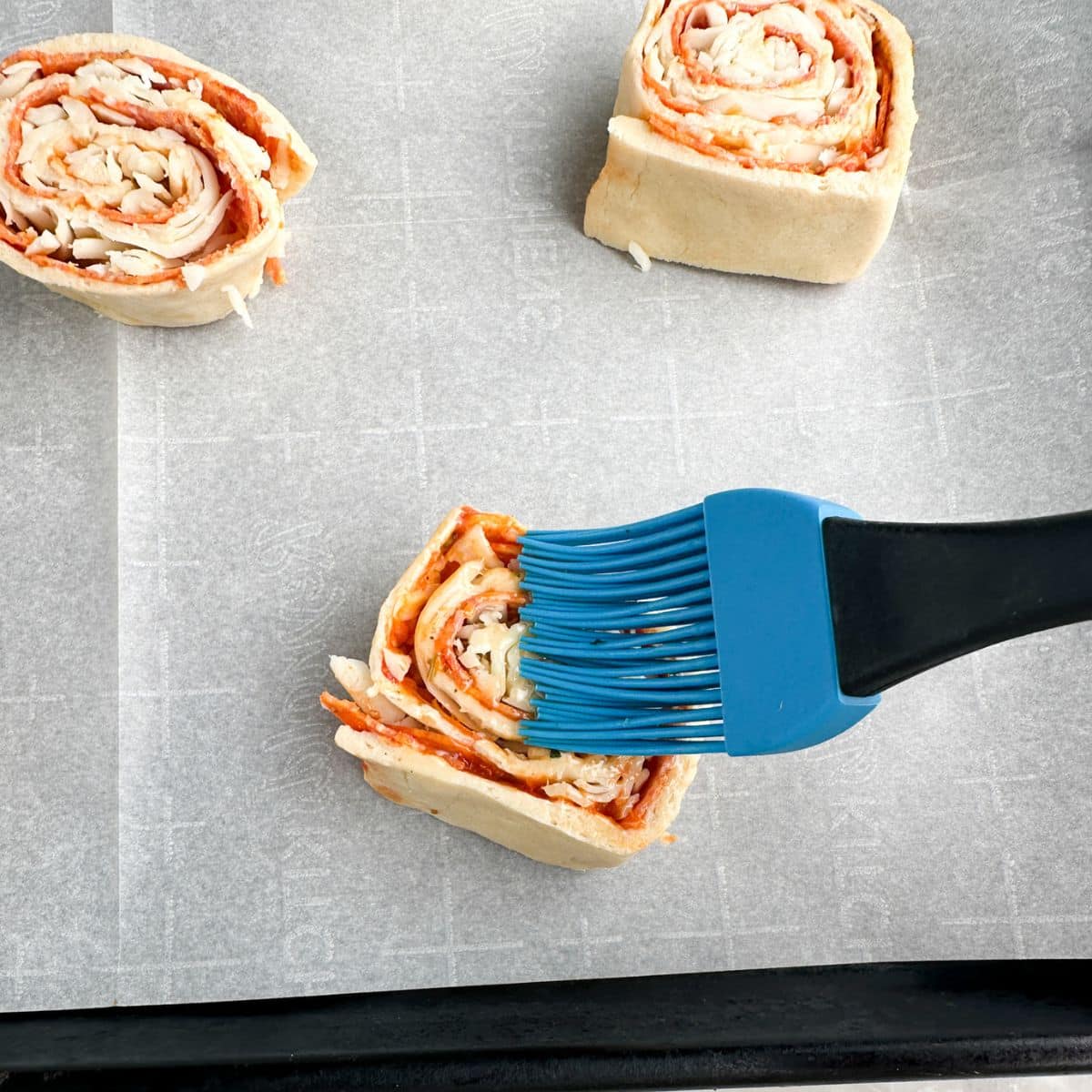 Pinwheels with butter being brushed on them. 