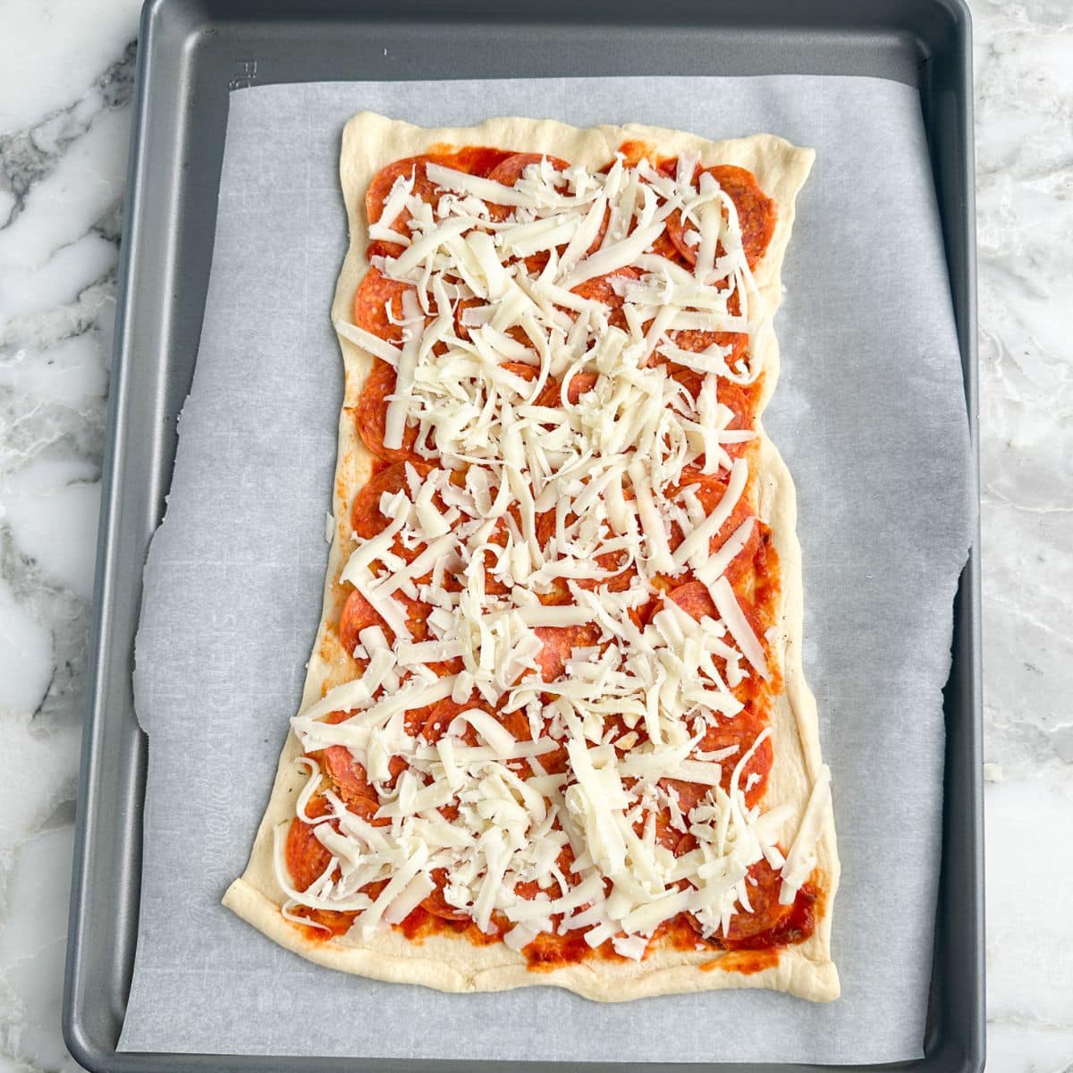 Crescent roll dough with sauce, pepperoni, and shredded cheese. 