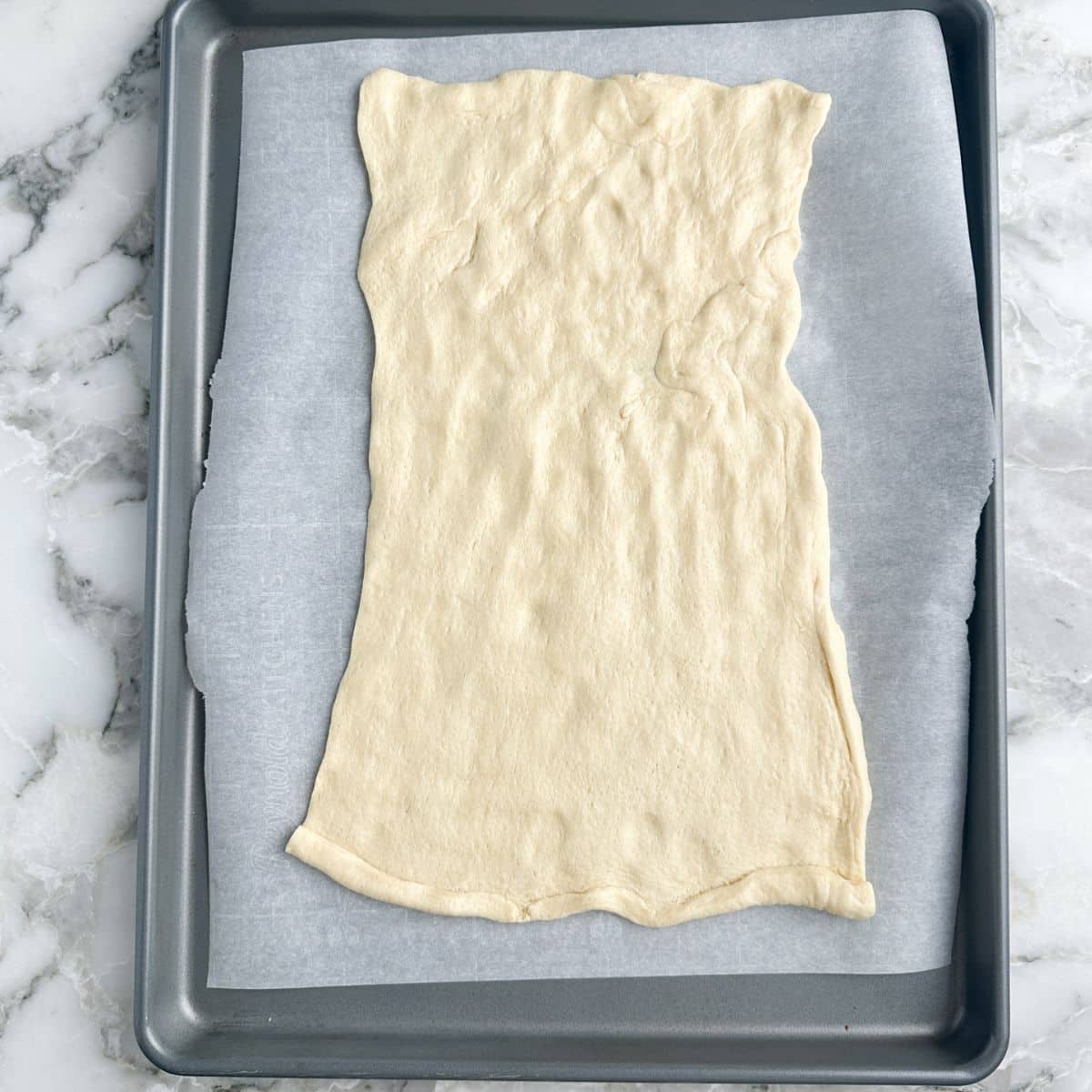 Crescent dough laid out on a baking sheet. 