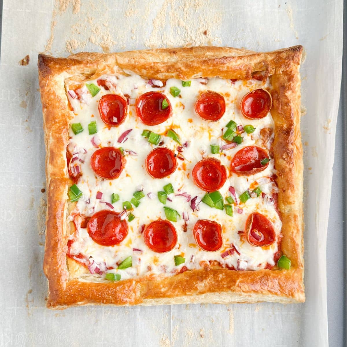 Puff pastry pizza on a pan.