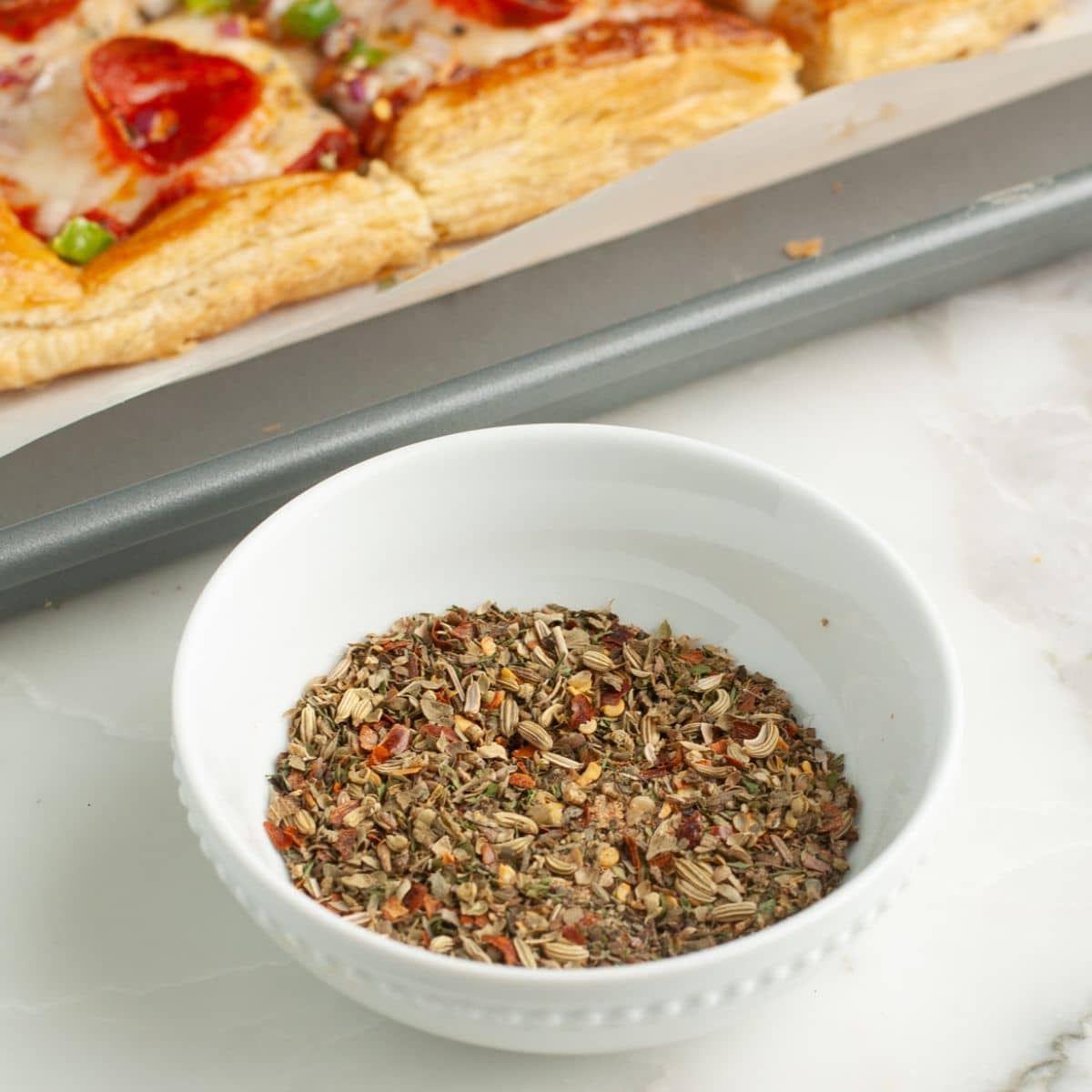 Bowl with pizza seasoning. 