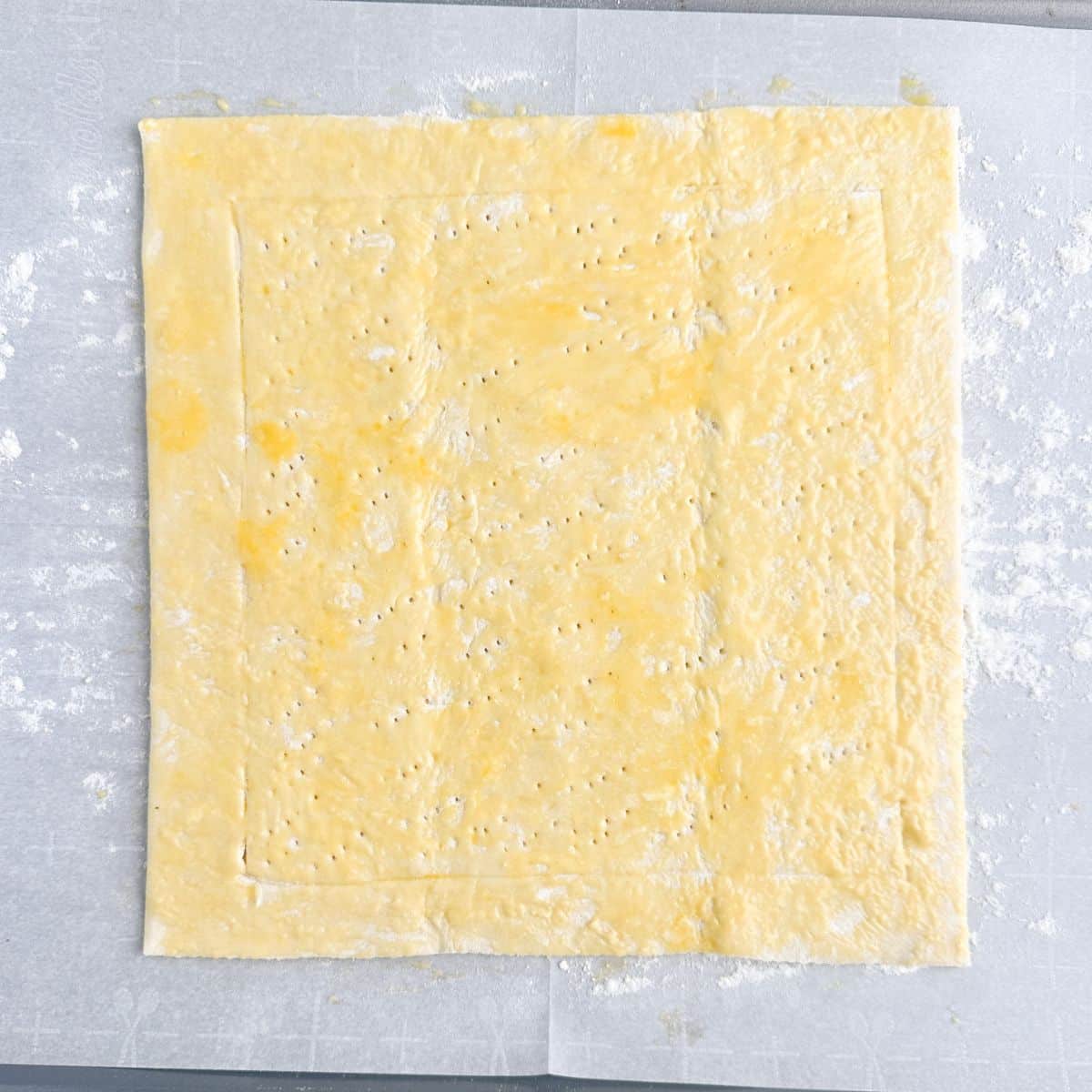 Puff pastry dough covered in egg wash.