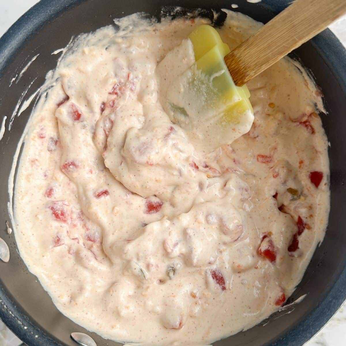 Bowl with queso and a spatula.