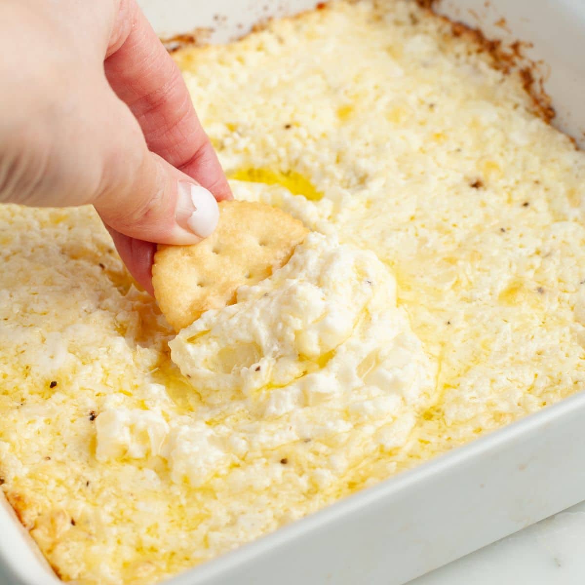 Baked onion dip with a cracker. 