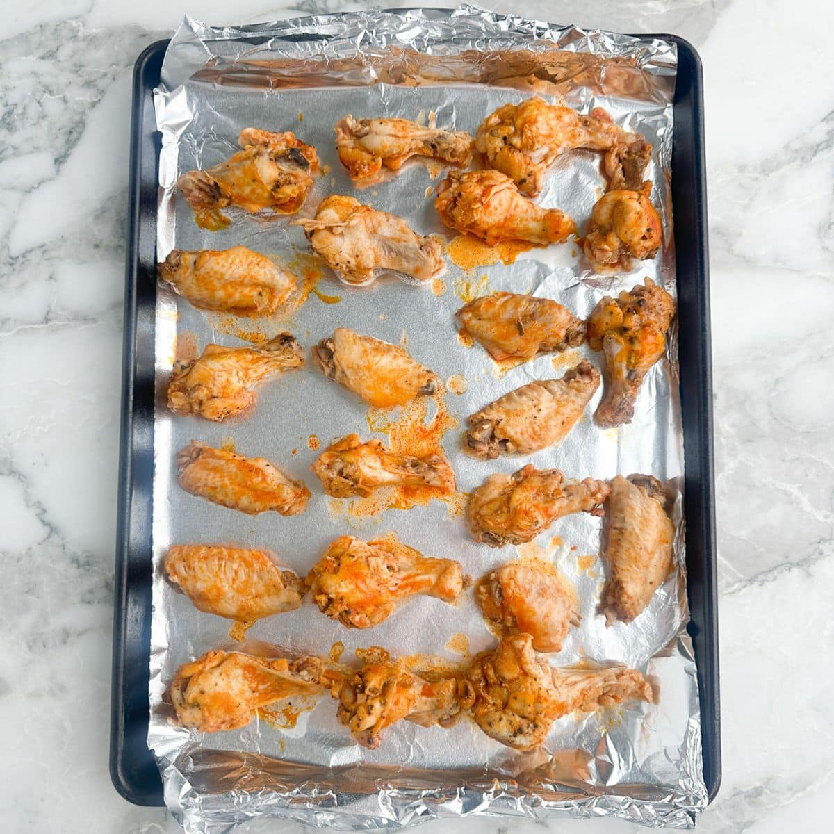 Cooked chicken wings on a baking dish.