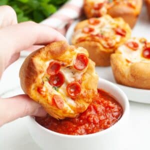 Pizza cupcake dipping into marinara sauce.