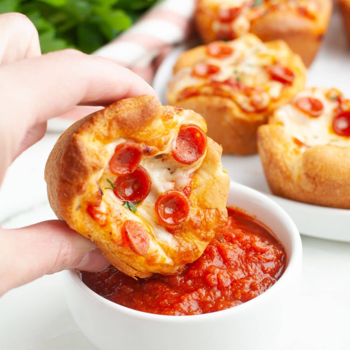 Pizza cupcake dipping into marinara sauce. 