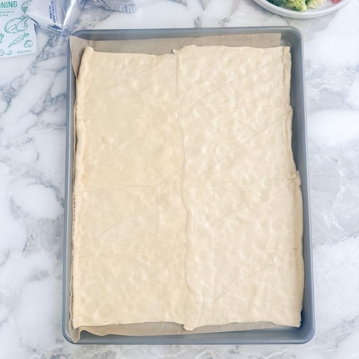 Crescent roll dough on a baking pan. 