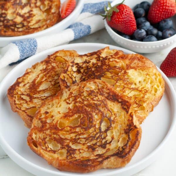 Plate of french toast with a bowl of berries.