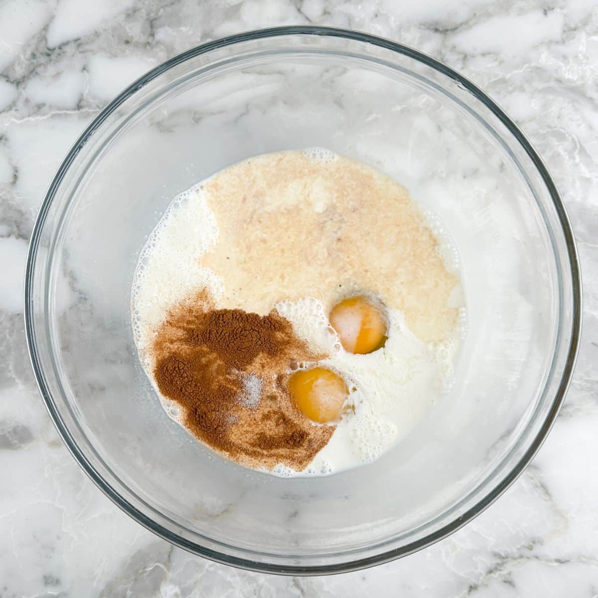 Bowl of eggs, milk, cinnamon, and vanilla.