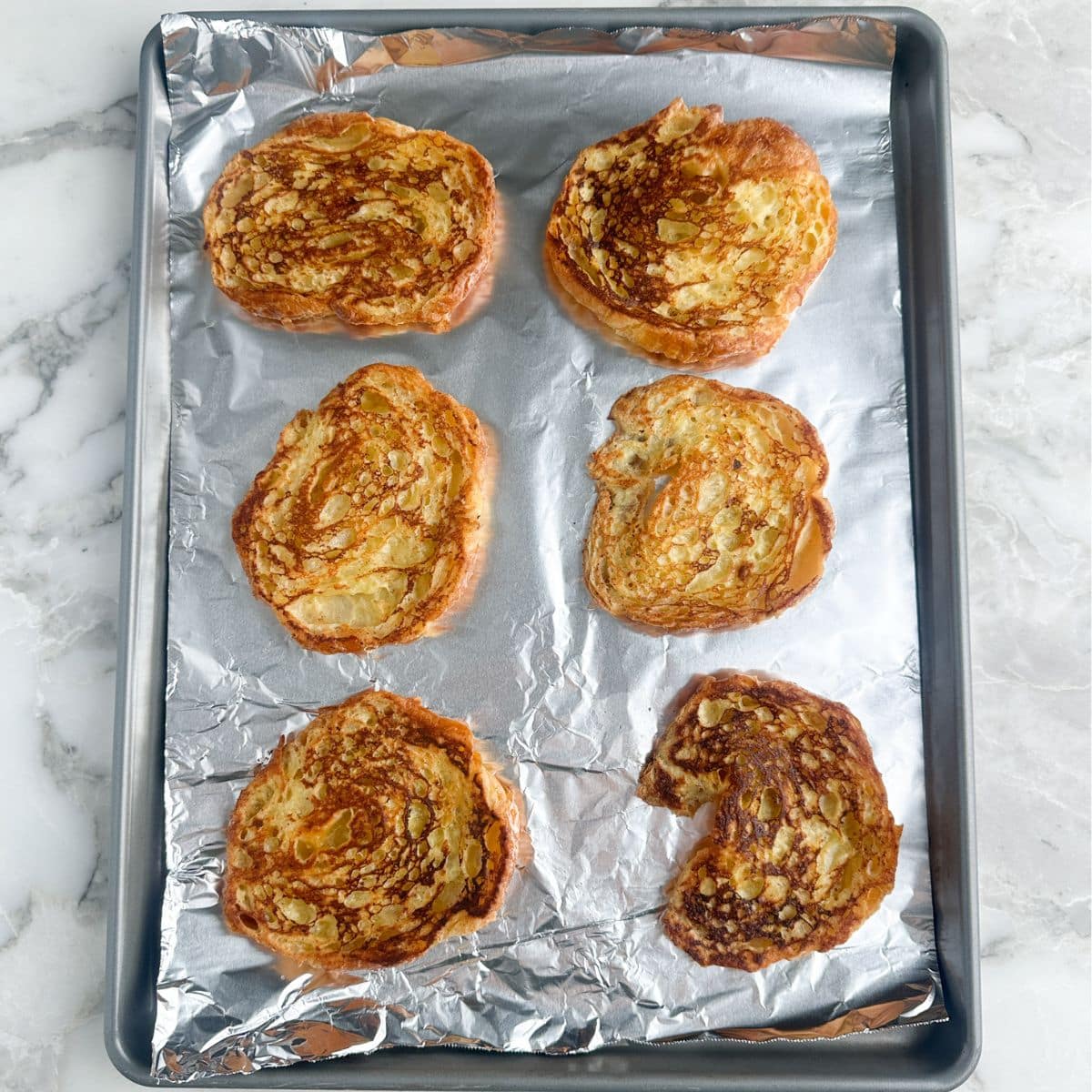 Pan with cooked croissant french toast.